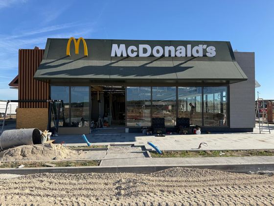 Façade d'un restaurant avec son enseigne et son logo posés sur un bardage.